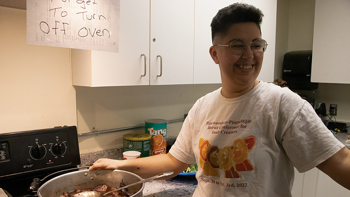 Photo 2edit In the kitchen, a woman stands in front of the oven over a pot of seal ribs