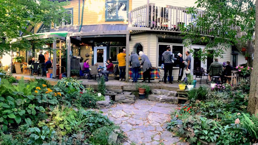 A full view Terra Firma's residents of Terra Firma gathered together outside enjoying their Sunday dinner. 