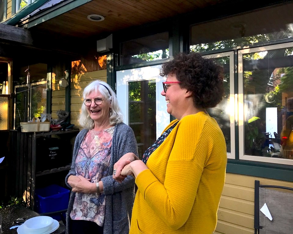 Heidi Smith and Marlene Neufeld engaging a small conversation about Smith's hopes of living in cohousing.