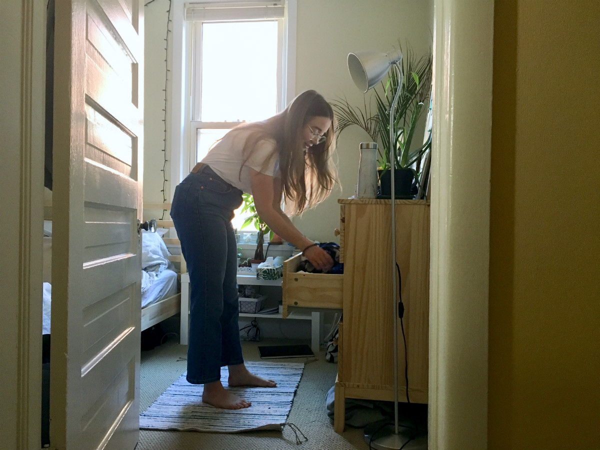 A woman sorts through her dresser.