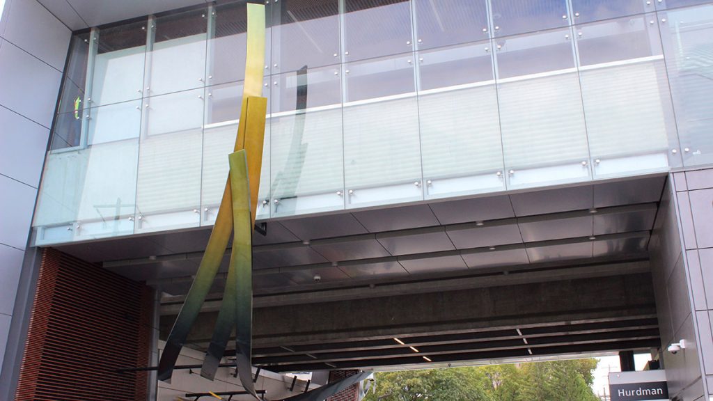 Jill Anholt's metallic structure, meant to represent the flight pattern of birds, if hanging from the building at Hurdman station.