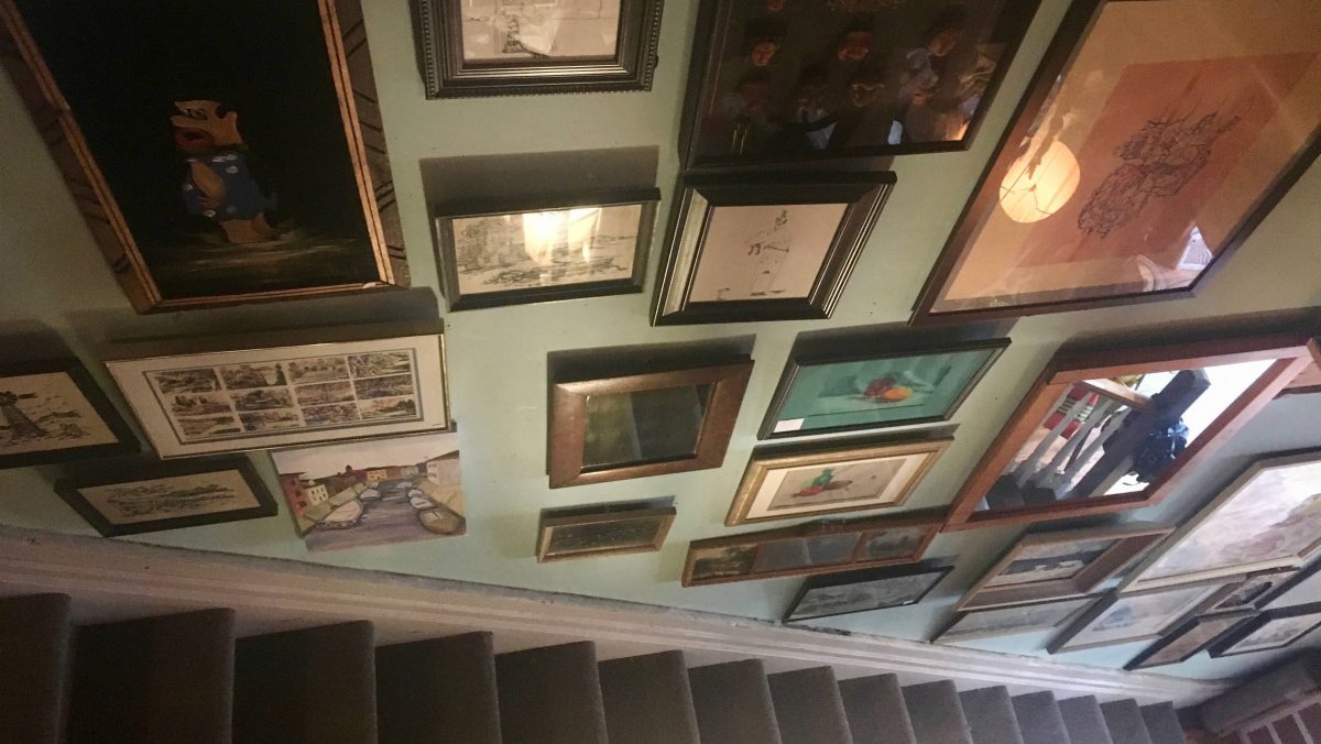 A black staircase with photos hanging on the wall beside.