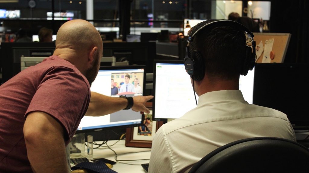 Skube and colleagues eyeing two computer screens. 
