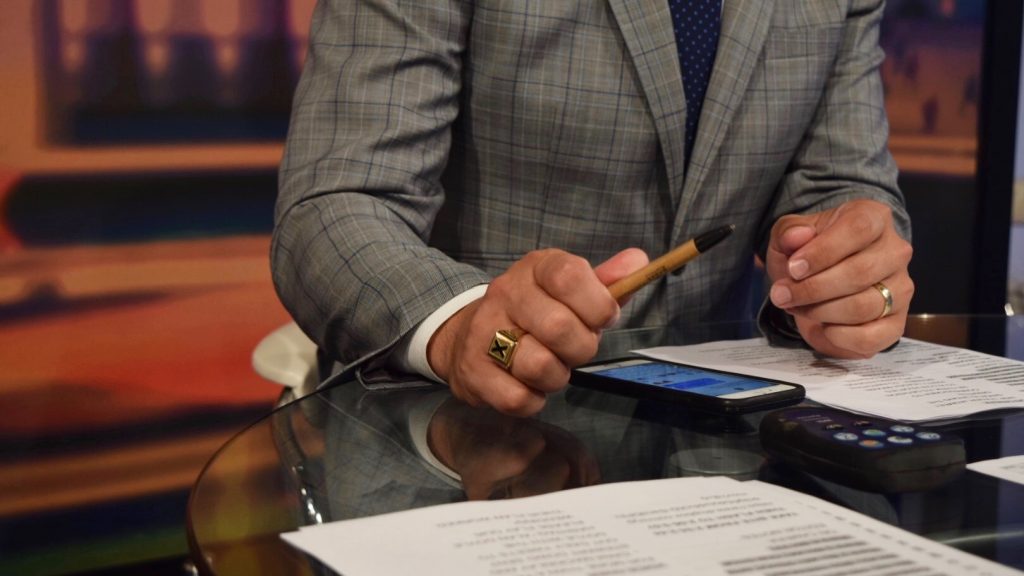 Skube holding a pen as he sends a last text message before recording. 
