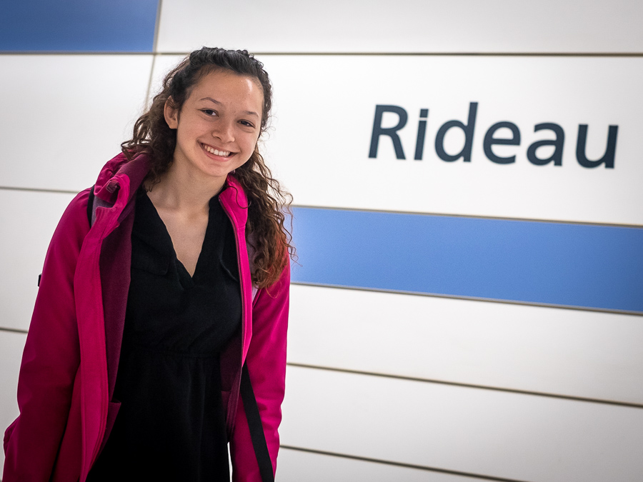 Nathalie Lawson smiles at the camera in front of a wall that says "Rideau"