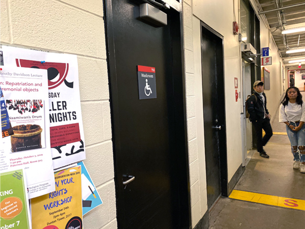 A door for one of Carleton's genderless washrooms is shown. It is also marked as accessible.