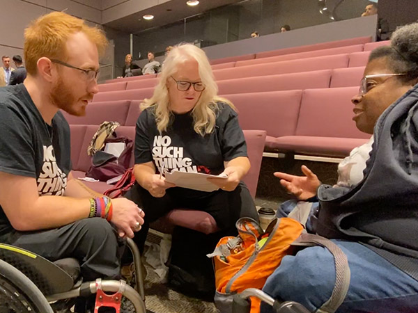 Kyle Humphrey, his mother, and Sally Thomas discuss at City Hall.