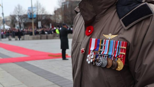 Veteran dressed in uniform with close up of awarded medals.