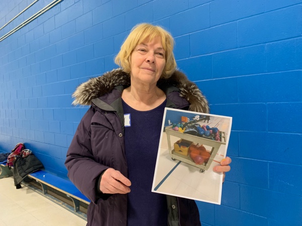 Sandy Kusugak is holding a photo of her equipment. 