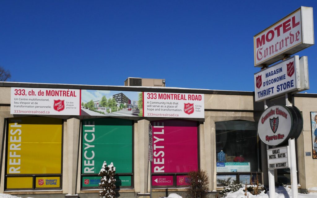 Posters displaying plans for the proposed shelter hanging on the side of Motel Concorde.