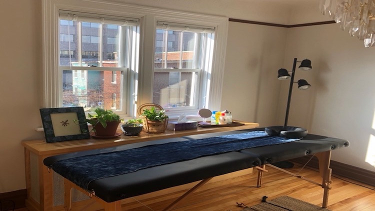 A photo of a massage table by a well-lit window.