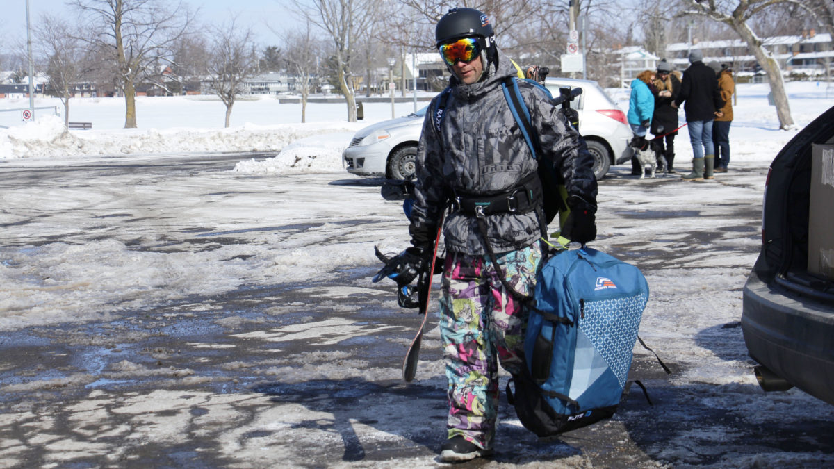 Campbell carries his kiteboarding gear through the parking lot.