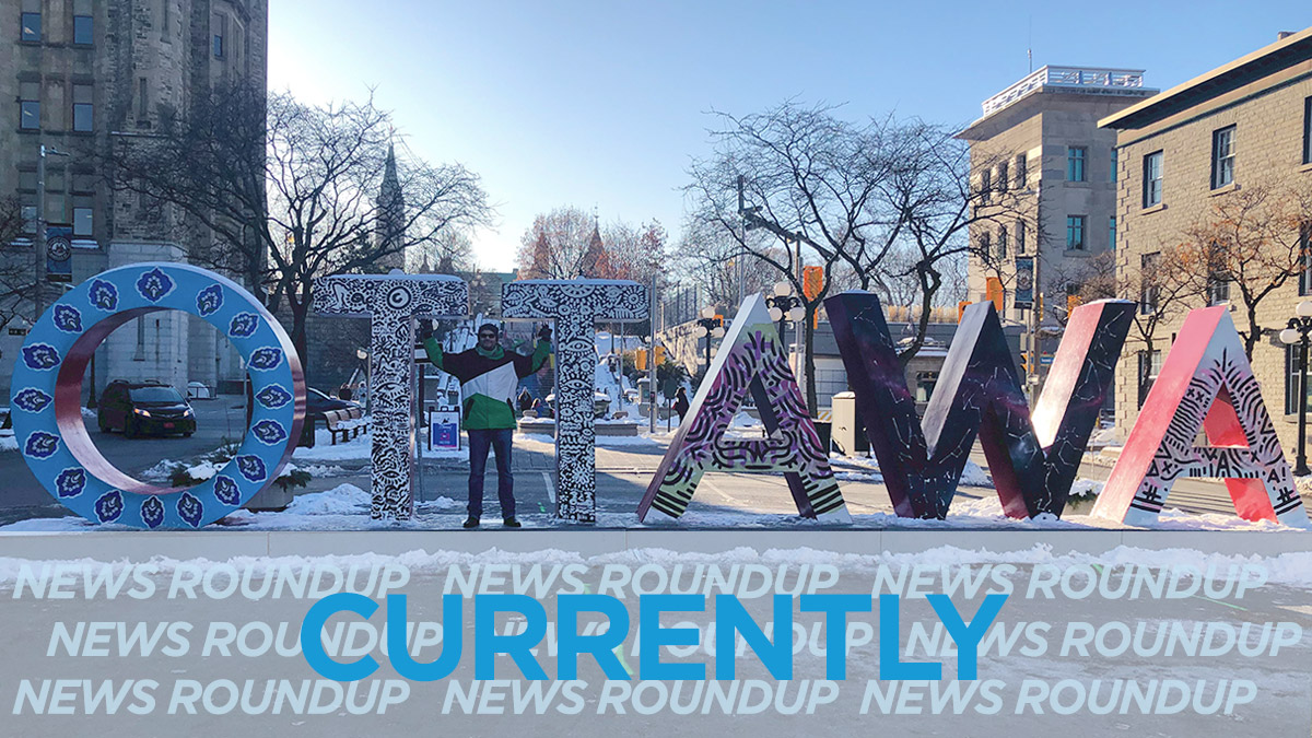 Man stands in front of large Ottawa sign in the Byward market