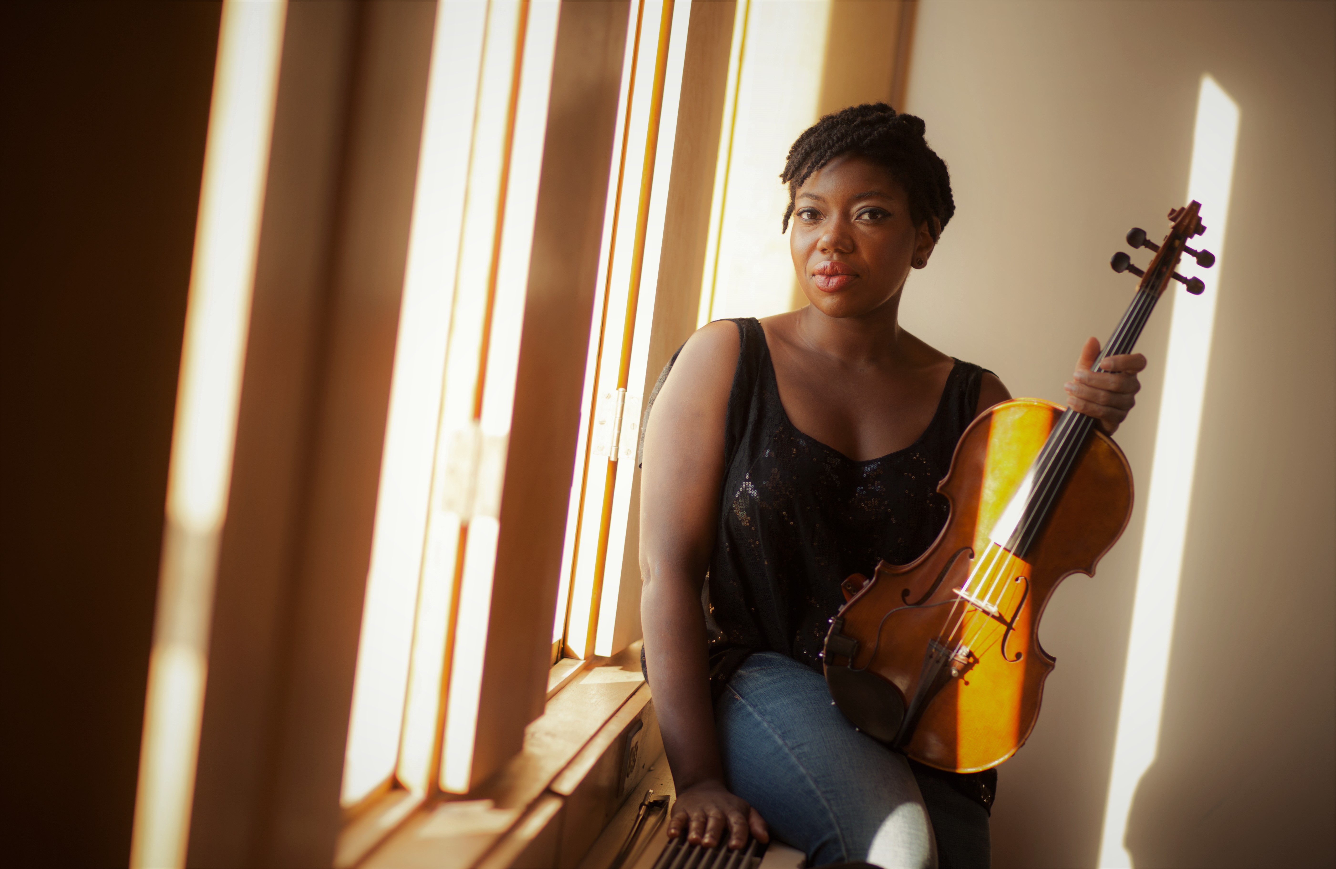 Kathryn Patricia Cobbler sits by the window with her violin