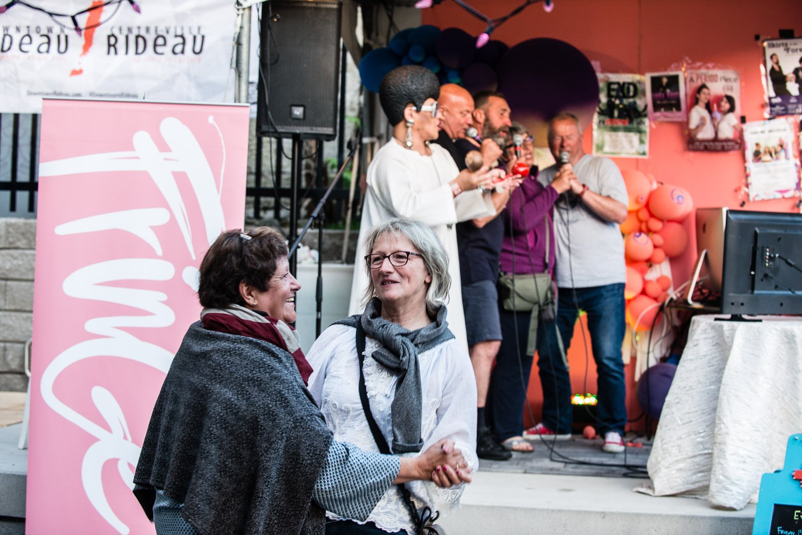 Two festival goers dance together as a group sings karaoke at Ottawa Fringe Festival in 2019.