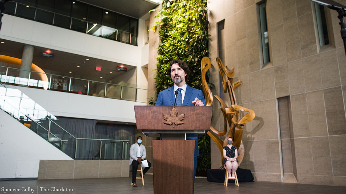 Prime Minister Justin Trudeau stands behind a podium at Carleton University to give his morning briefing