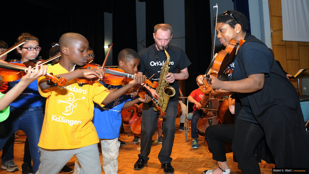 Teaching Artist Kathryn Patricia playing violin with members of the OrKidstra