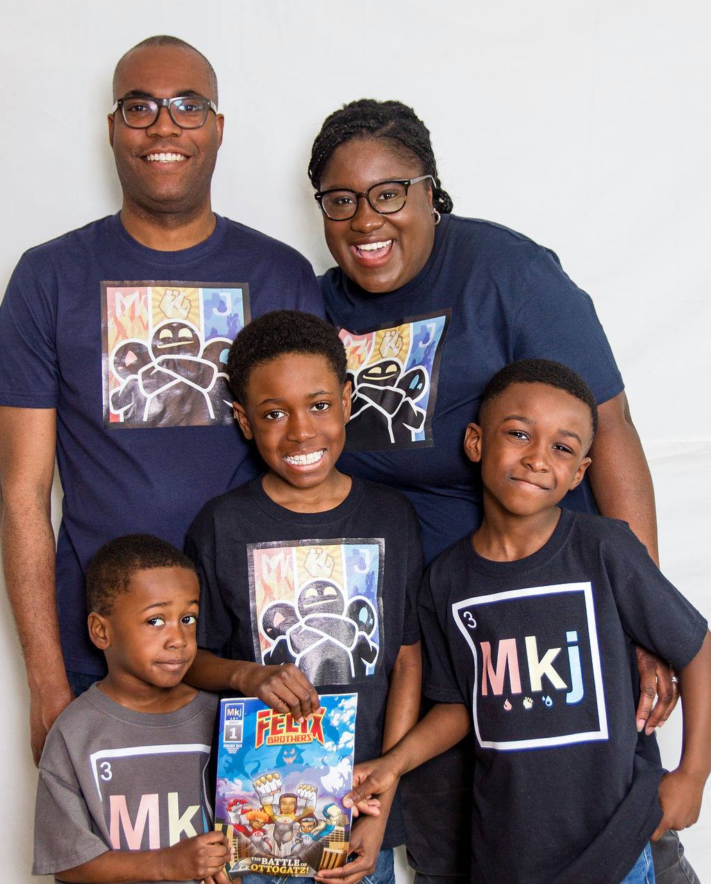 A photo of Nahomie Acelin, Ronald Felix and their three sons holding a copy of the comic book. 