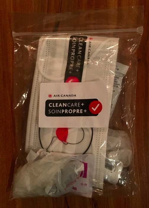 Air Canada handed out a package to passengers that includes a mask, gloves, hand sanitizer, disinfectant wipes, and pretzels. (Photo credit © Nalini Raman-Wilms)