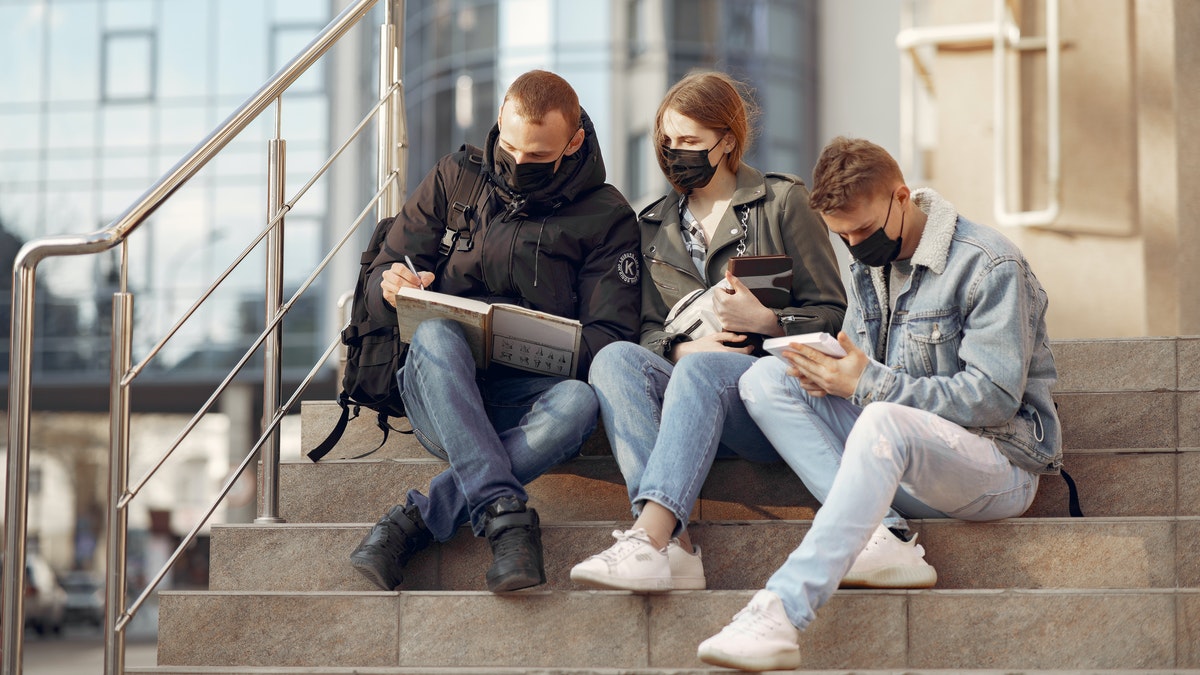 Stock photo of students at a university wearing protective masks.