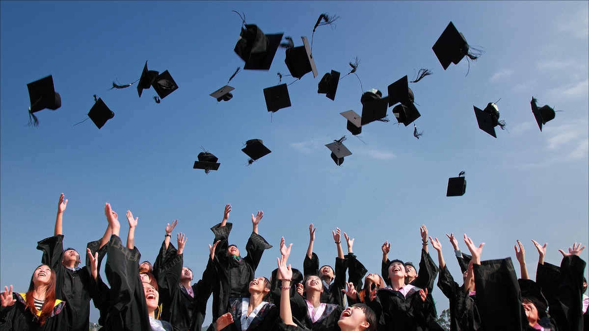 Graduates throwing up their caps