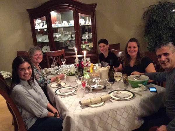 A photo of Kathy Ivers table sitting around a table and smiling at the camera. 