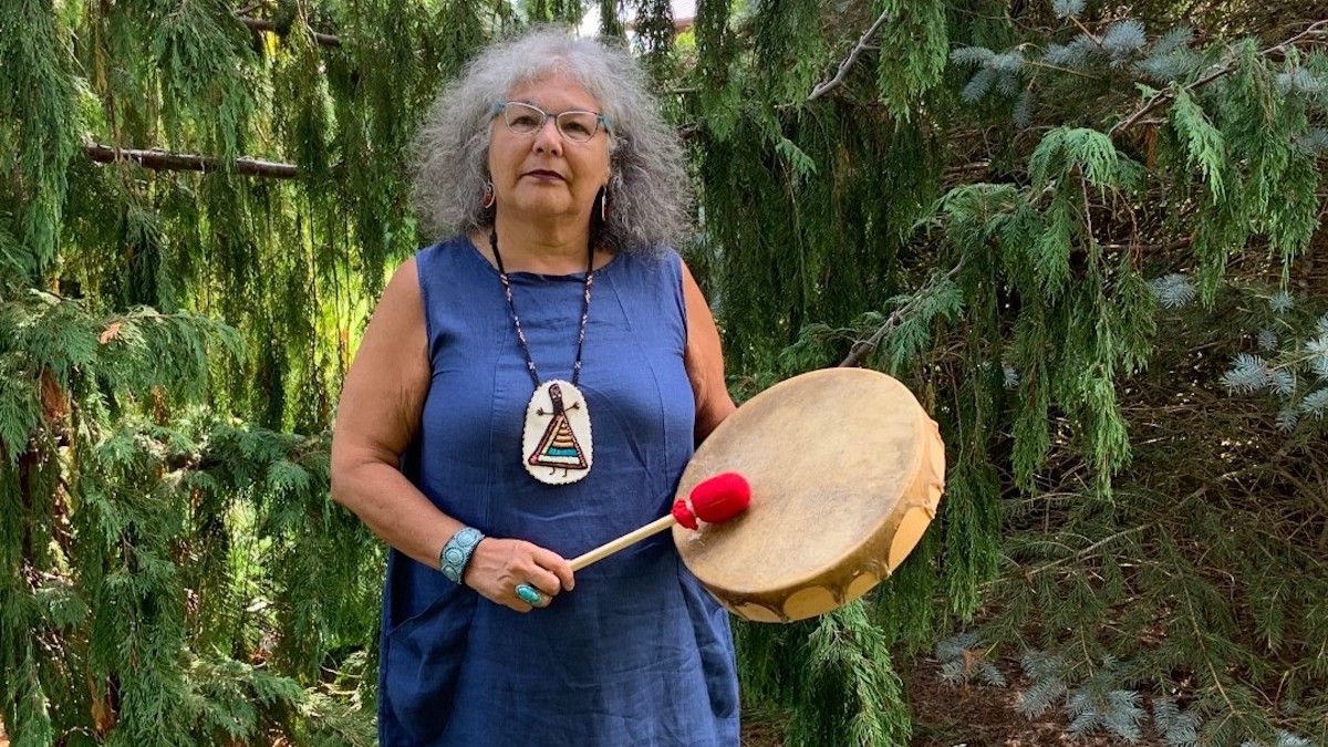 Lorraine Whitman stands with a drum.