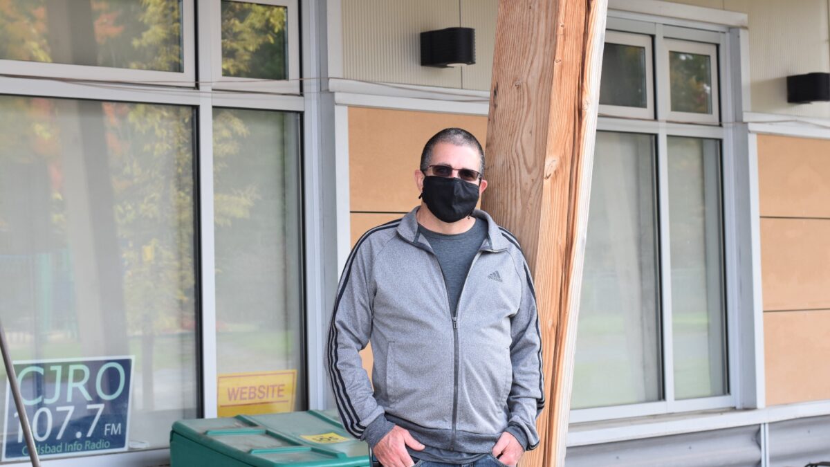 Denis LaBreche standing outside the Carlsbad Springs Community Centre, with his hands in his pockets and wearing a mask.