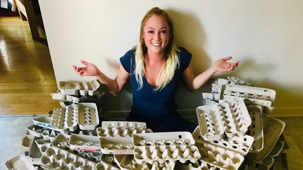 earthub founder Brittanny Belanger sits on the floor surrounded by empty egg cartons
