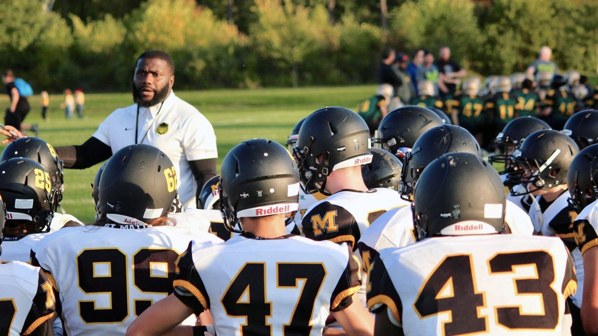 Jean-Sorphia Guillaume speaks to a group of St. Matthew football players.