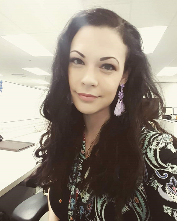 Edith Chartier smiles for a selfie in an office setting