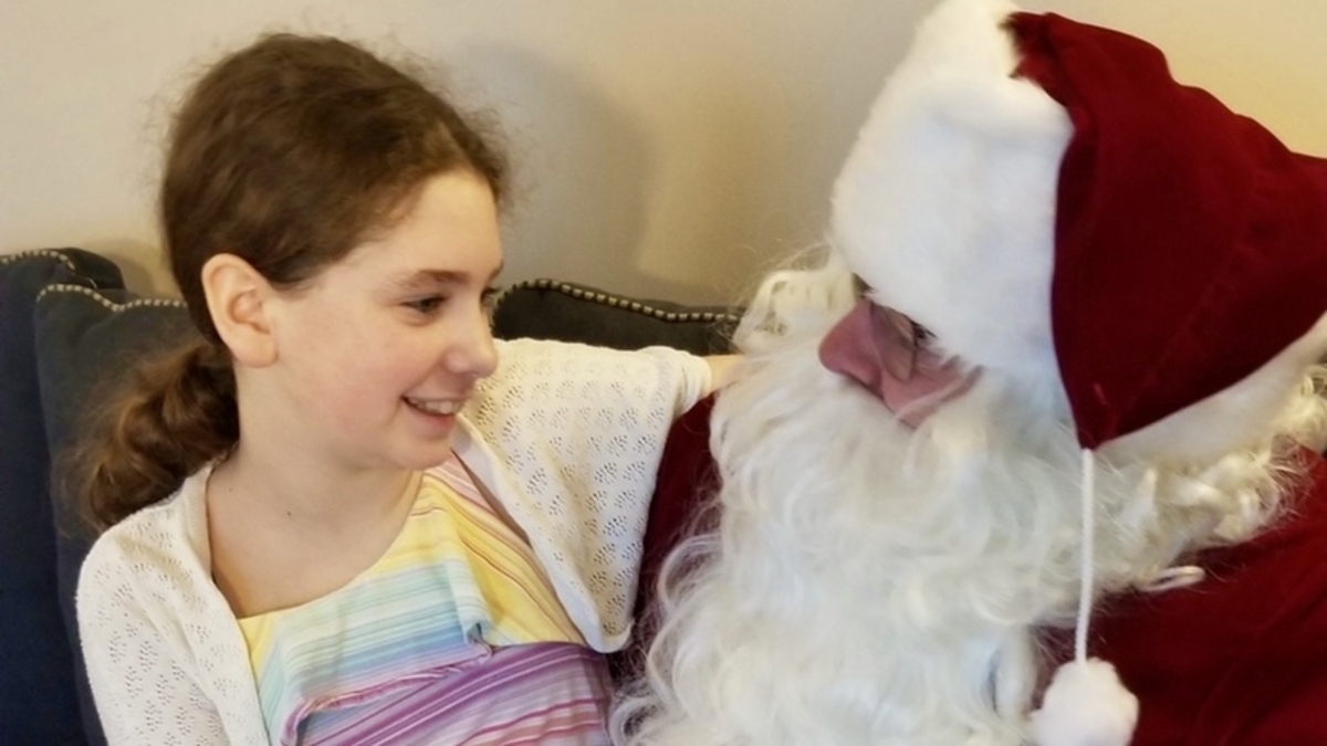 Al Sullivan dressed as Santa with his young daughter in his lap. He won't be able to get this interaction with people outside of his household this year.