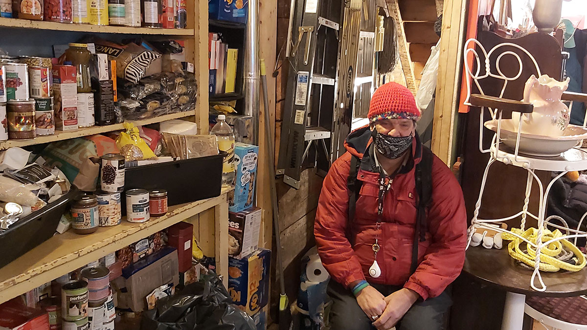 George Upchurch sits next to highjinx's food pantry where neighbours are welcome to come get any food they need for the next couple of days.