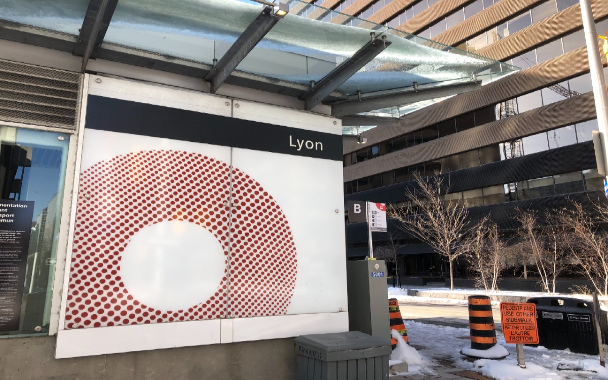 A photo of the sign outside of the Lyon LRT station, with snow on the ground