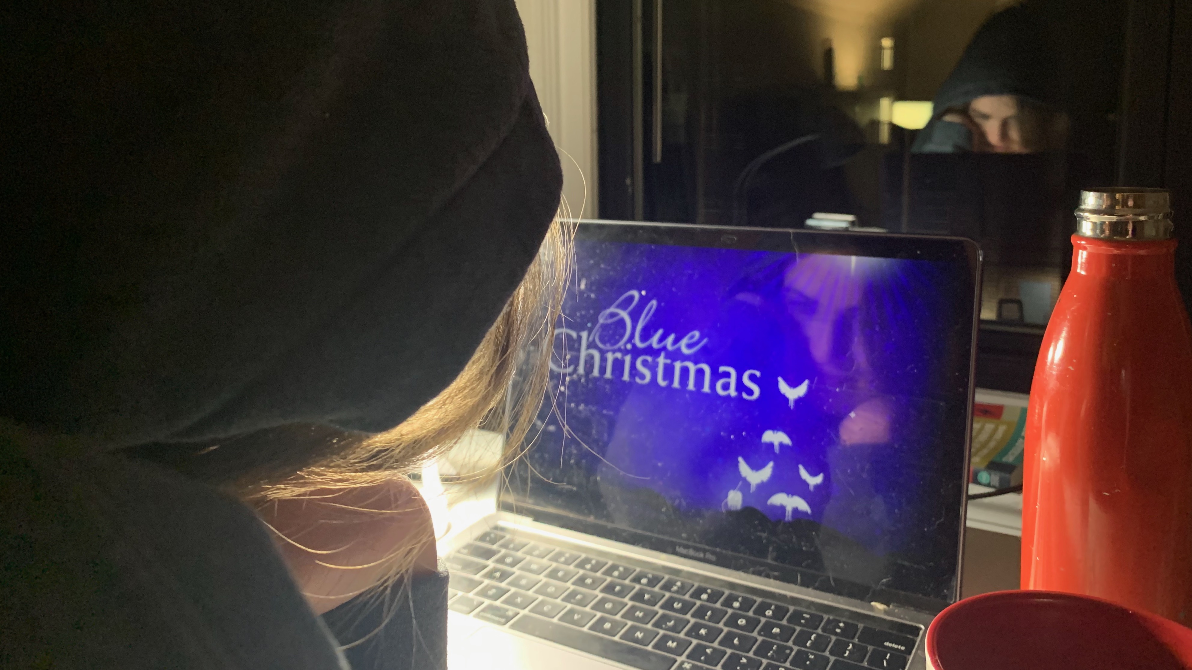 Person looking at a screen that says "Blue Christmas".