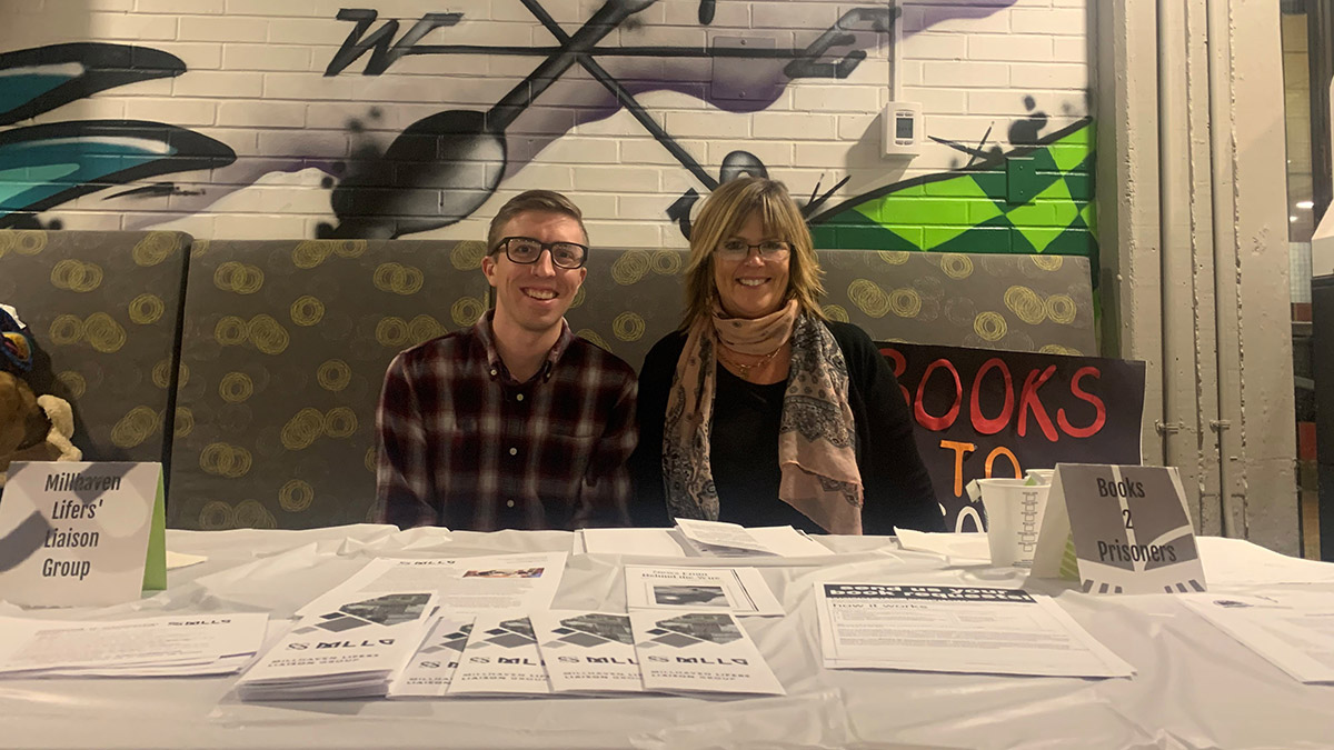 Jeff Bradley and Jane Crosby sit at a table with pamphlets in front of them.