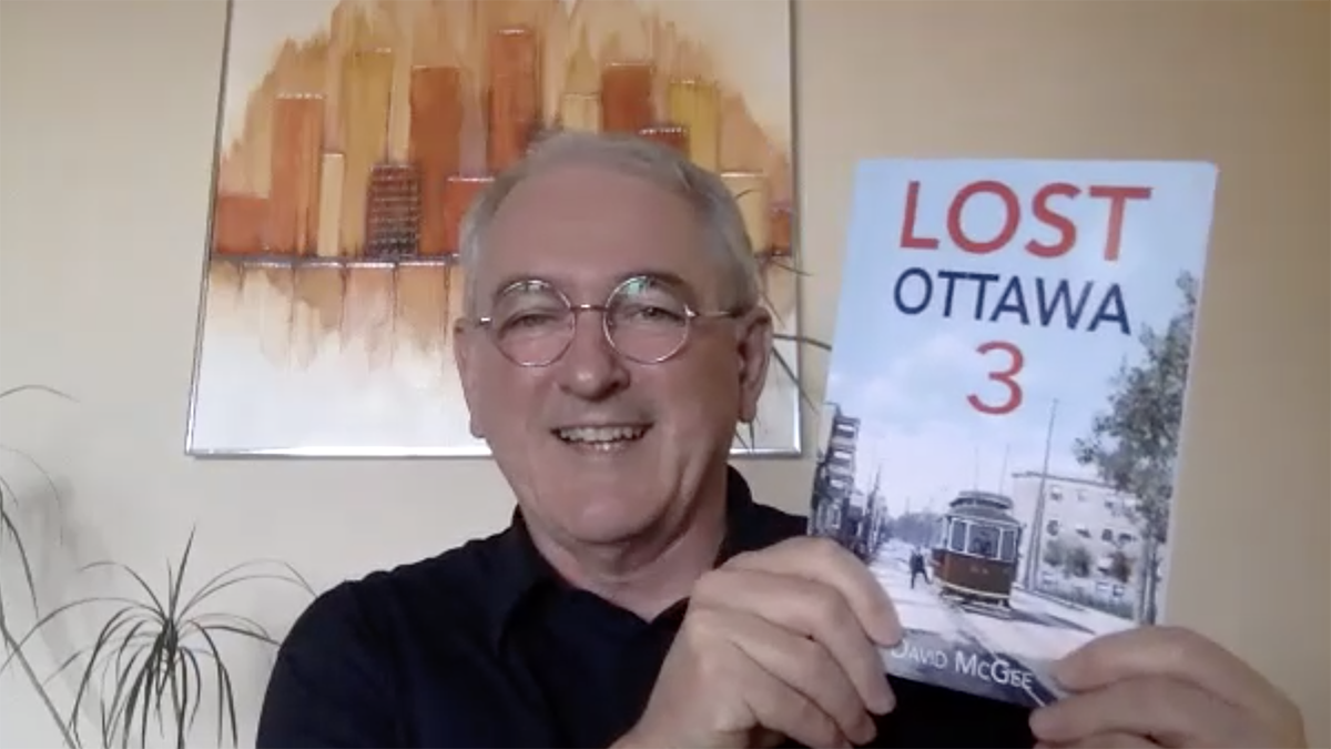 David McGee, author of Lost Ottawa 3, holds up a copy of Lost Ottawa 3 while smiling.