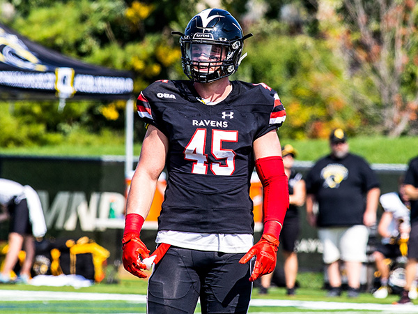 football player stands on field in full equipment