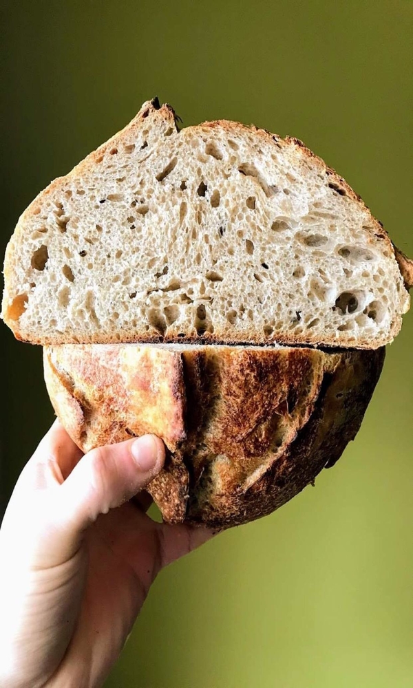 Hand holds two pieces of sourdough stacked on top of each other.