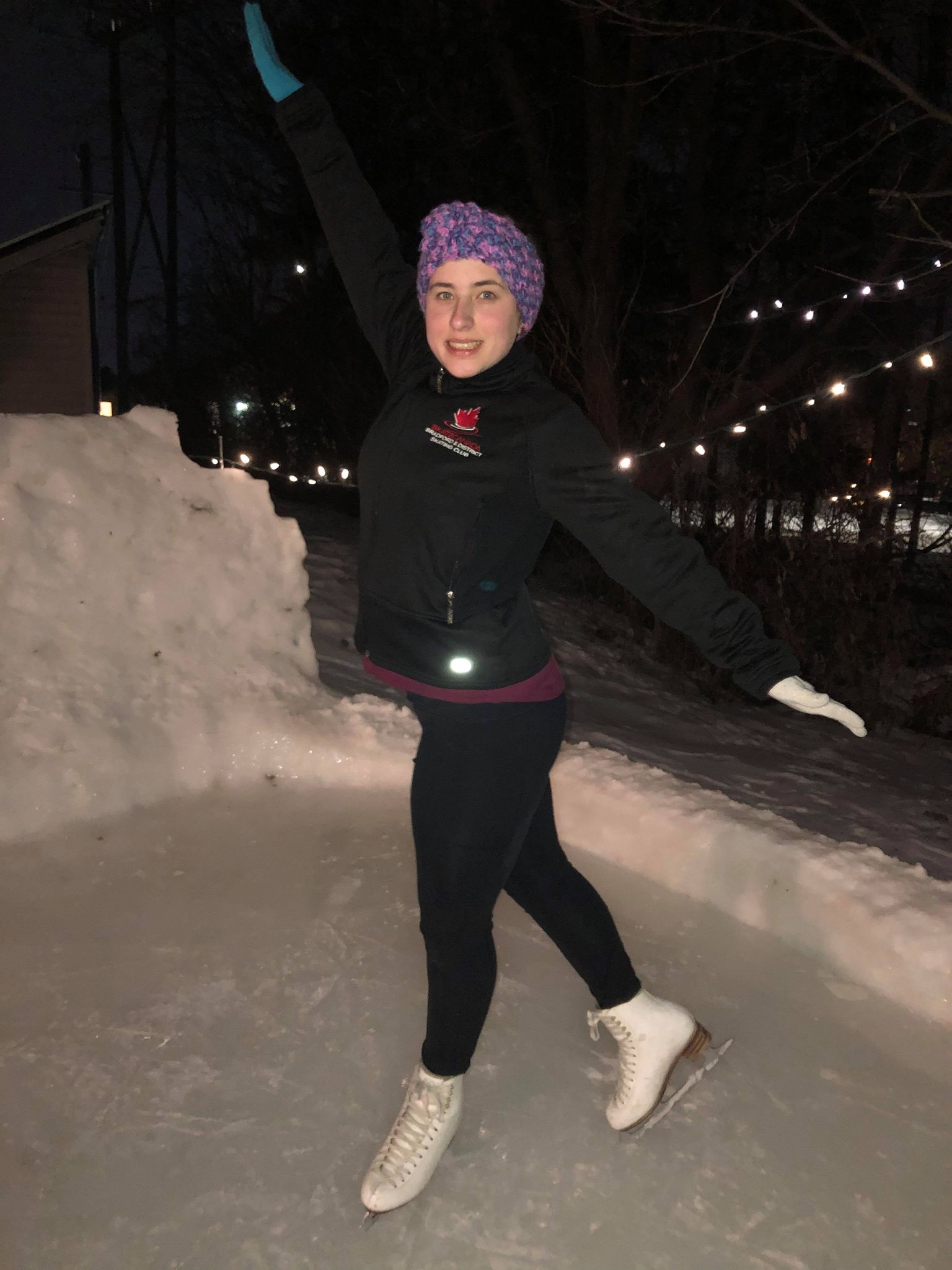 Skating girl poses for the camera on outdoor rink.