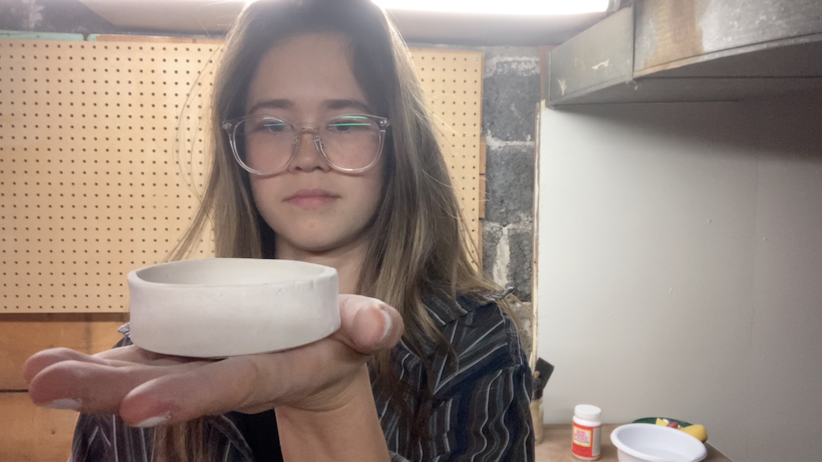 Vanessa holds up her pottery creation