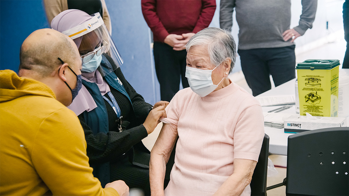 An elderly woman gets vaccinated.