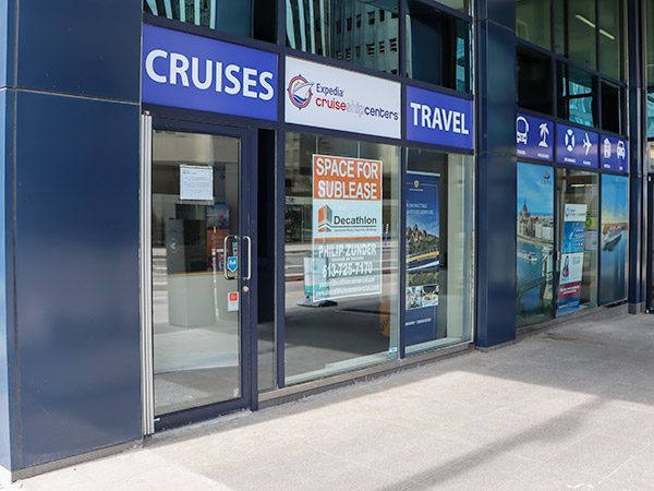 A travel agency with a sign in the window that reads "space for sublease".