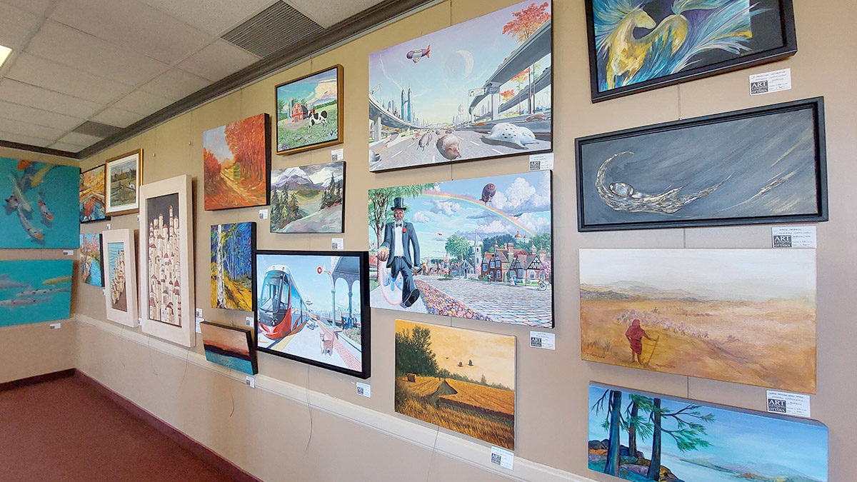 Paintings of different sizes hang on the wall.