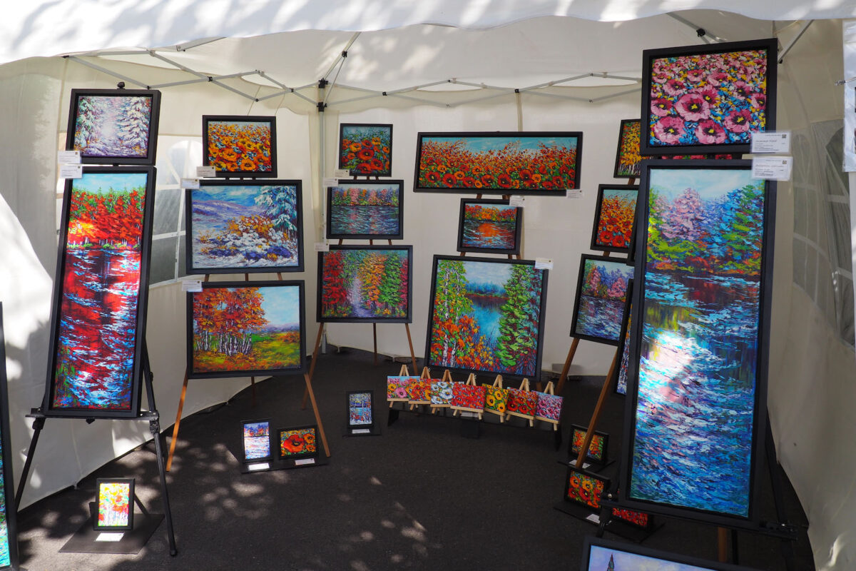 Vibrant and bright floral and landscape paintings displayed outside.