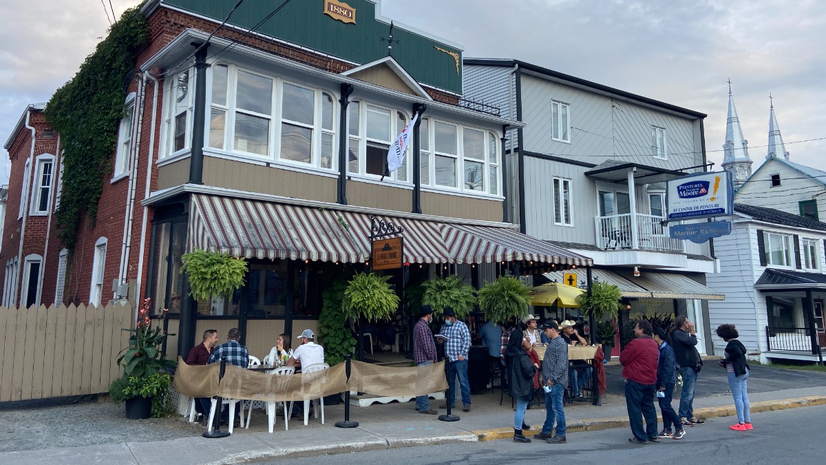 Customers spill out of a bar onto the streets as they drink and chat with friends in Saint-Tite during the festival.