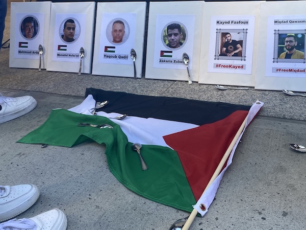 Printed out photos of escaped Palestinian prisoners on the ground, along with spoons and the Palestinian flag.