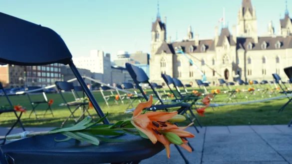 Orange flowers on rows of chairs overlooking the West Block at Parliament Hill.