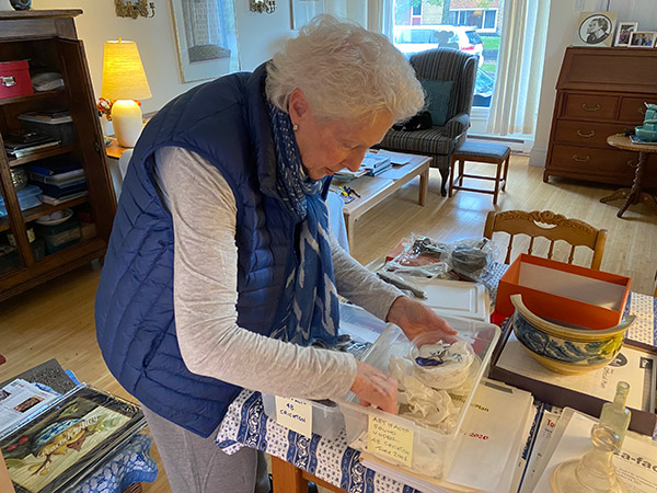 Gail McEachern looks through boxes of artifacts in her home, including pieces of broken plates from the 19th century.