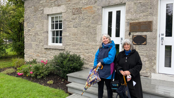 Martha Edmond and Janet Uren, co-authors of a history of New Edinburgh, stand in front of the Frasier Schoolhouse